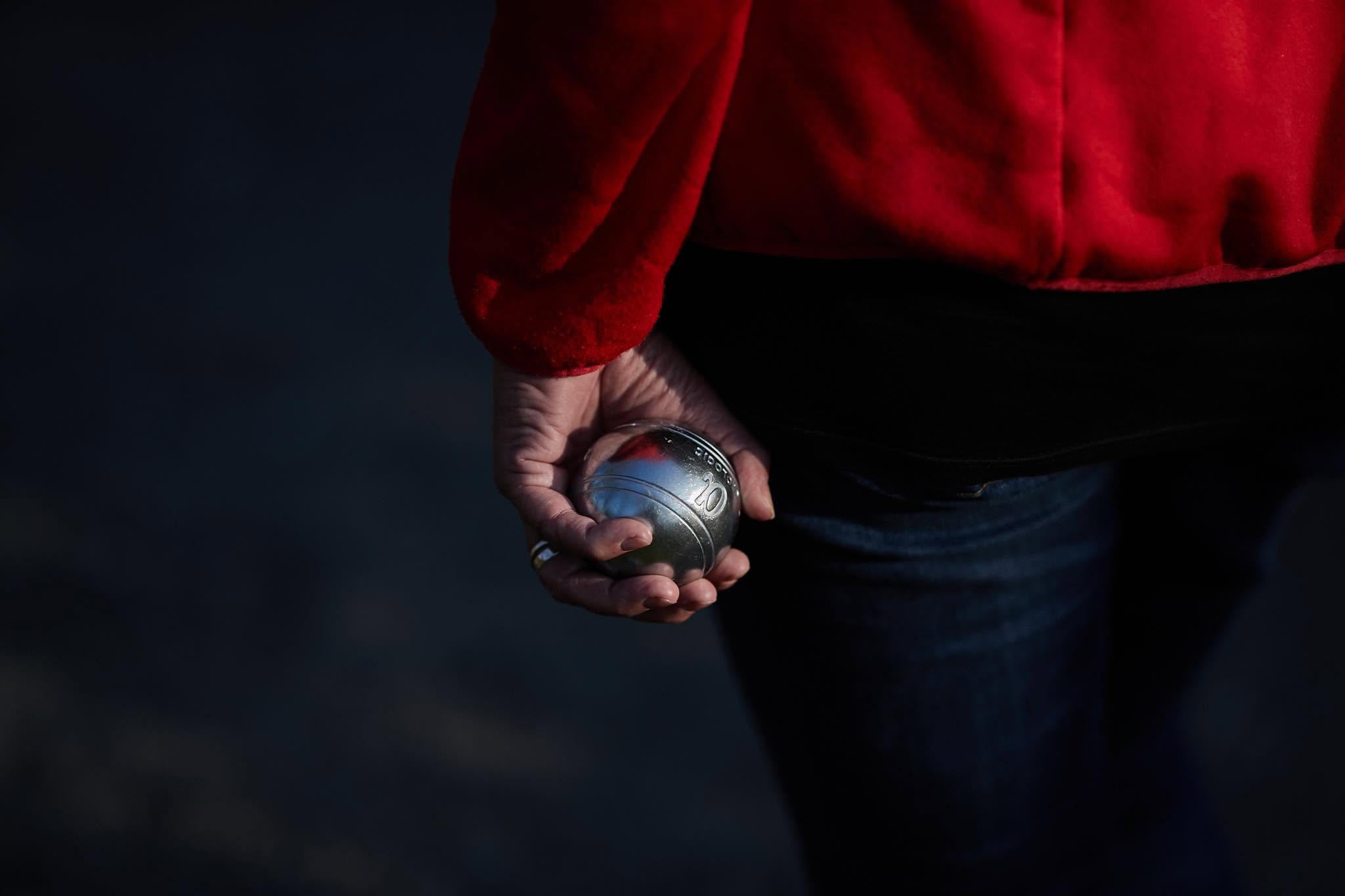 Die Boule-Kugel in der Hand.
